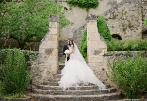 bride and groom on steps of french chateau featured
